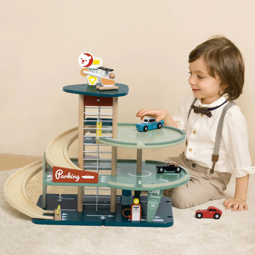 Criança a brincar com o Classic World Parking Vintage, colocando um carro azul no piso superior, demonstrando a interação e o tamanho do brinquedo.