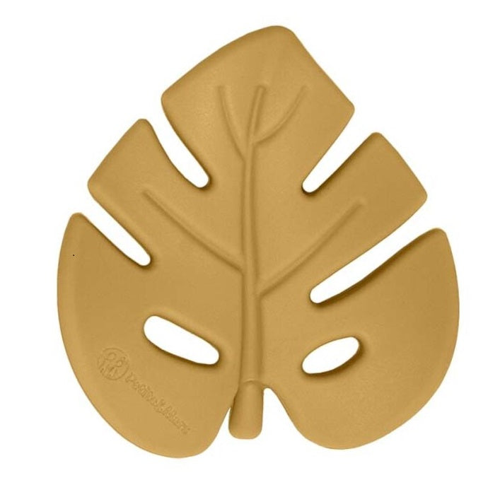 Mordedor de silicone amarelo mostarda em forma de folha (Monstera), com veios detalhados e logótipo Petite&Mars gravado, isolado em fundo branco.