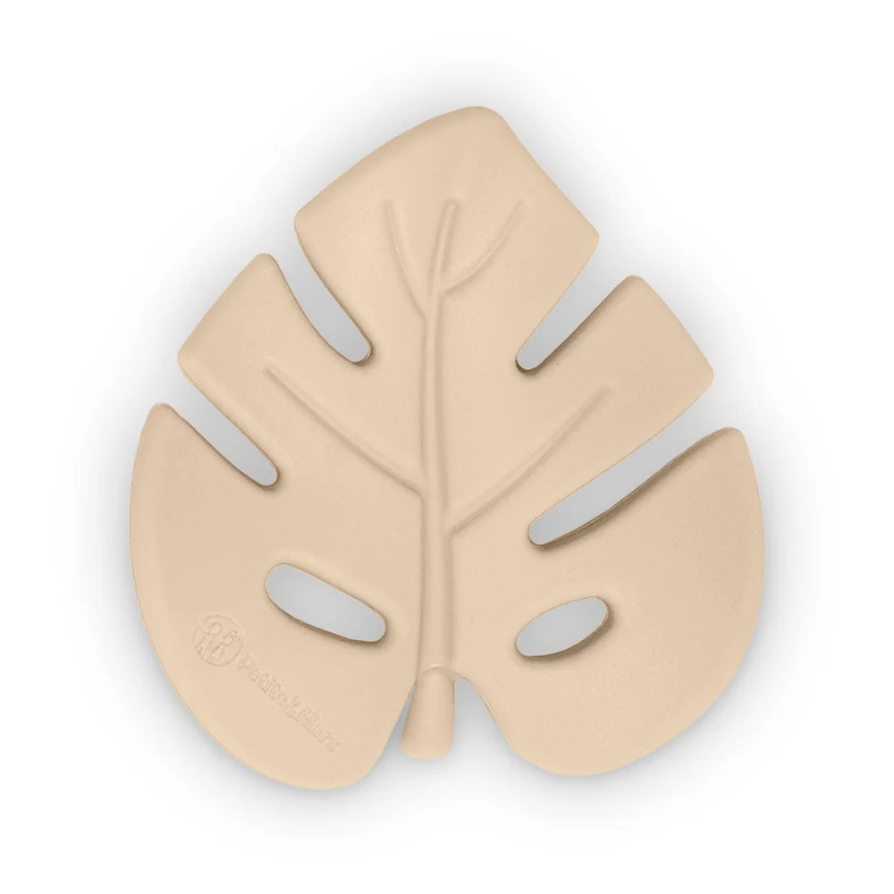 Mordedor de silicone bege claro em forma de folha (Monstera) com relevo dos veios e logótipo Petite&Mars, apresentado isolado em fundo branco.
