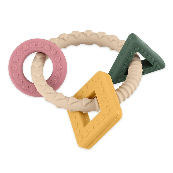 Mordedor de silicone Petite and Mars com formas geométricas (anel, quadrado, triângulo) em tons pastel de rosa, amarelo, verde-escuro e bege.