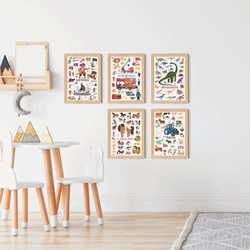 Quarto infantil com vários posters Poppik emoldurados na parede, incluindo o tema Jungle, sobre uma mesa e cadeiras brancas.