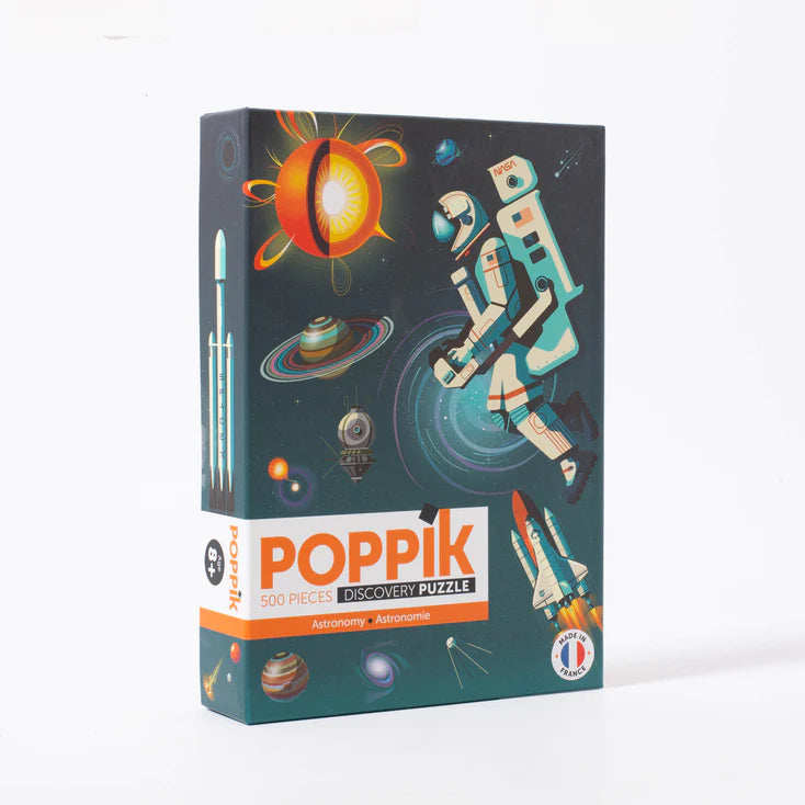 Caixa do puzzle Poppik Astronomy de 500 peças com ilustração de um astronauta, sol e foguetão no espaço.