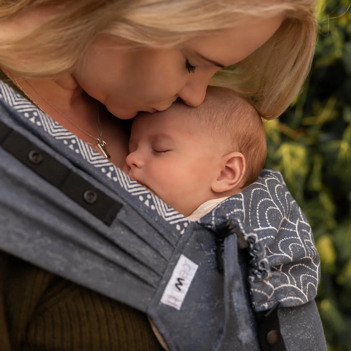 Mãe a carregar um bebé recém-nascido na mochila Hoppediz Primeo Sapporo.