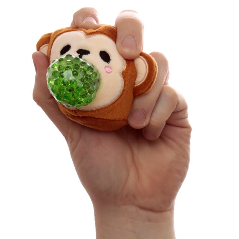Mão a espremer um Adoramal Queasy Squeezies da Puckator em forma de macaco, mostrando as contas verdes no interior.