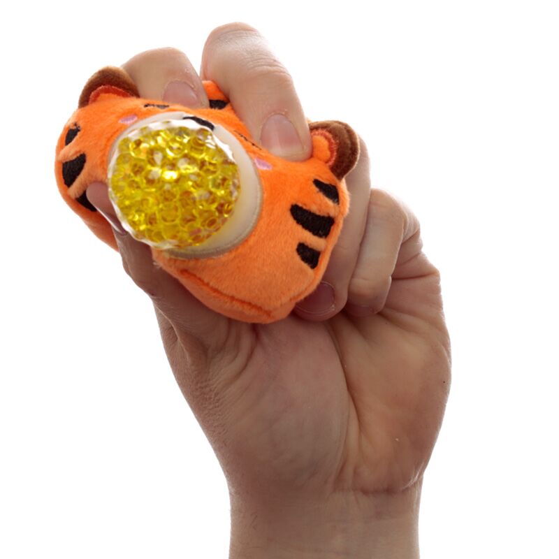 Mão a espremer um Adoramal Queasy Squeezies da Puckator em forma de tigre, mostrando as contas amarelas no interior.