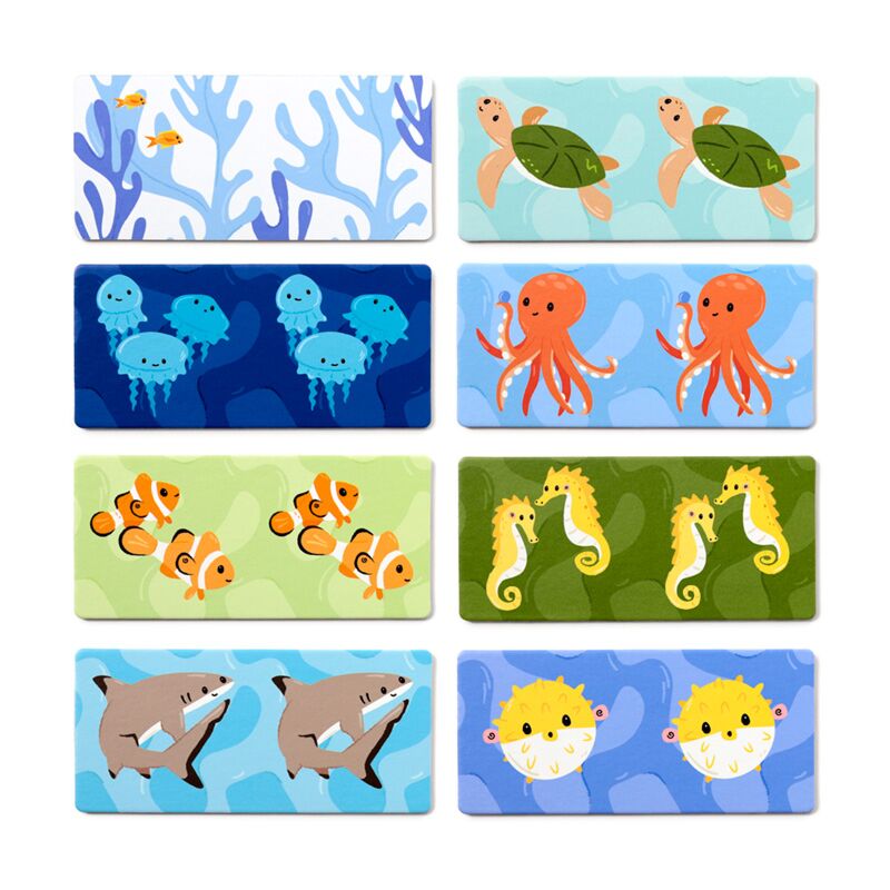Detalhe das peças individuais do dominó, mostrando as ilustrações vibrantes de animais marinhos como tartarugas, polvos, peixes-palhaço e tubarões.