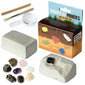 Kit de escavação Puckator com bloco de gesso, ferramentas (martelo, pincel, lupa) e 8 minerais e gemas expostos.