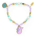 Pulseira infantil da Djeco da coleção Plume, decorada com contas peroladas, roxas e douradas, e três pendentes em metal esmaltado: uma sereia, um peixe e uma concha.