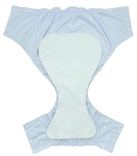 Absorvente Pupus Junior posicionado sobre uma fralda pull-up azul para crianças dos 5 aos 12 anos.