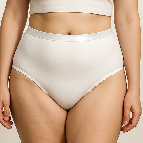 Mulher a vestir cuecas absorventes brancas de cintura subida com elástico acetinado confortável.