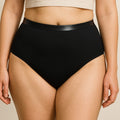 Mulher a usar cuecas absorventes pretas de cintura subida Pupus para incontinência leve.