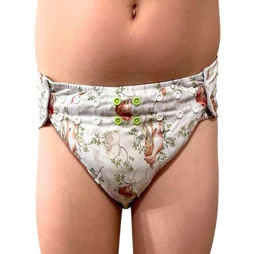 Criança a utilizar a fralda Pupus Junior mostrando o ajuste ergonómico das molas na cintura e coxas.