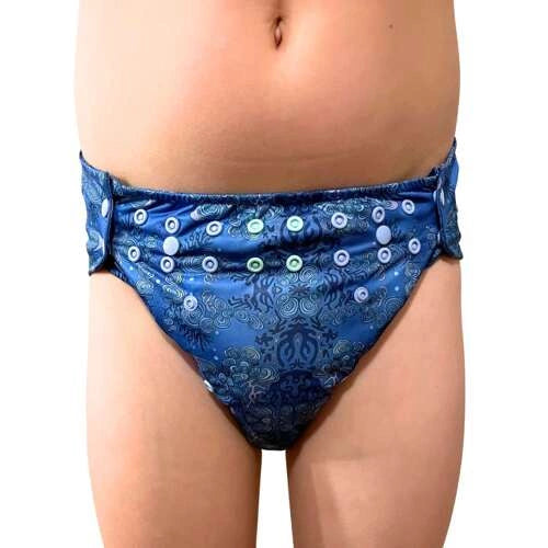Criança a usar a fralda Pupus Junior REEF mostrando o ajuste ergonómico na cintura e pernas.