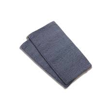 Par de protetores de alças Quokkababy em tecido azul denim, dobrados, ideais para proteger mochilas durante a dentição.