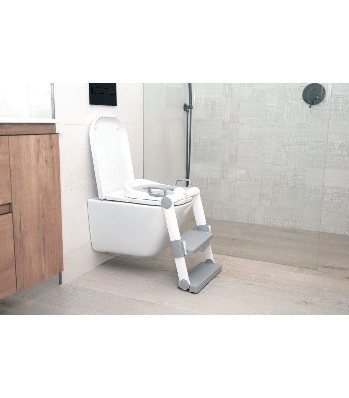 Olmitos Redutor de Sanita com Escada branco e cinzento instalado numa sanita de casa de banho moderna.