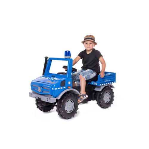 Criança sentada no RollyToys Unimog camião polícia azul, com luz azul no tejadilho, em fundo branco.