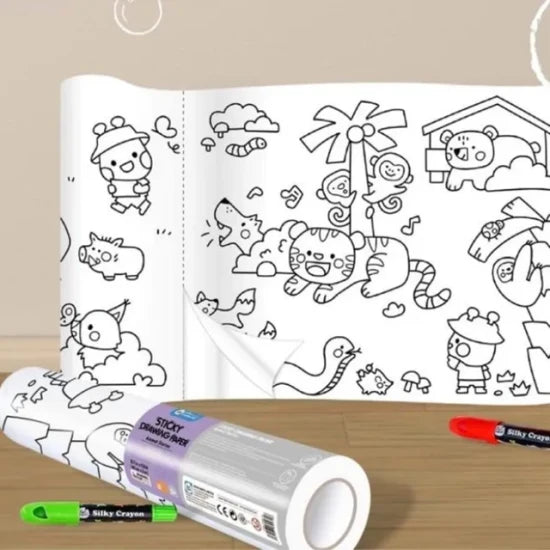 Rolo de papel de colorir autocolante parcialmente desenrolado sobre uma superfície, com marcadores de cor verde e vermelho visíveis ao lado.