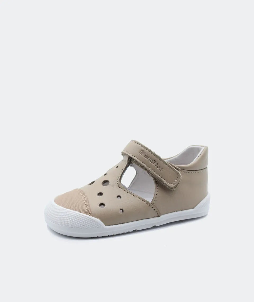 Sandália barefoot bege para bebé com fecho de velcro, biqueira reforçada em borracha e sola flexível.
