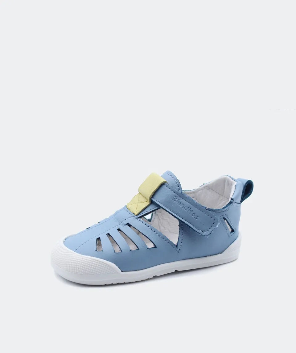 Azul – Sandália Fiyi da Blanditos by Crio's em tom azul, com fecho de velcro e detalhes em couro, sola fina branca e biqueira reforçada.
