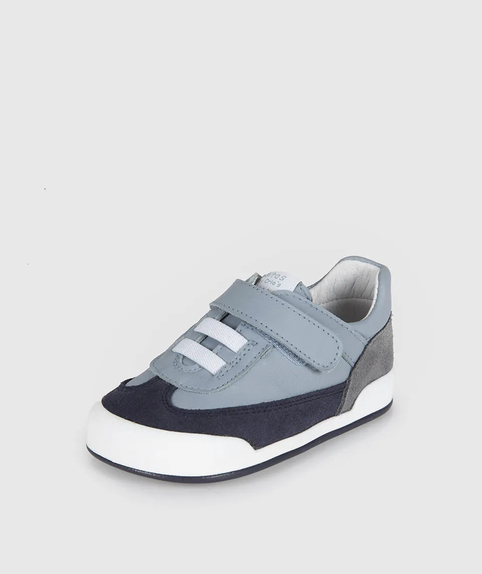 Sapatilha infantil Blanditos by Crio's Modena azul claro com detalhes em camurça azul escura e cinza, sola branca, atacadores elásticos e velcro. Vista lateral. Calçado Respeitador Barefoot. Calçado Barefoot.
