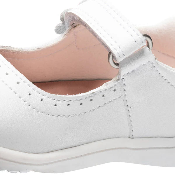 Detalhe da costura e da tira de velcro da sapatilha infantil branca, mostrando o interior forrado.