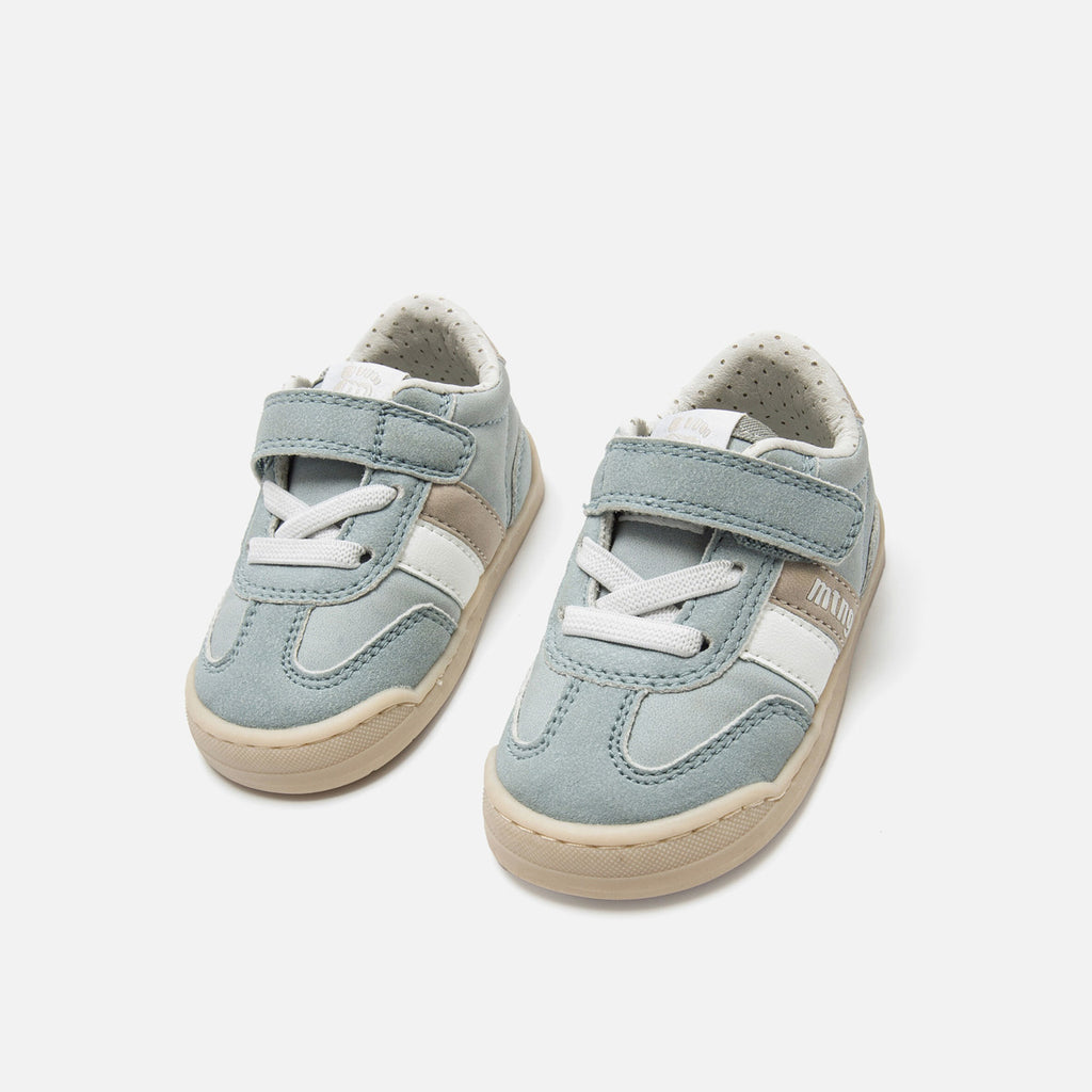 Par de sapatilhas Mustang infantis em tom azul esverdeado, com atacadores elásticos e tira de velcro, sobre fundo branco.