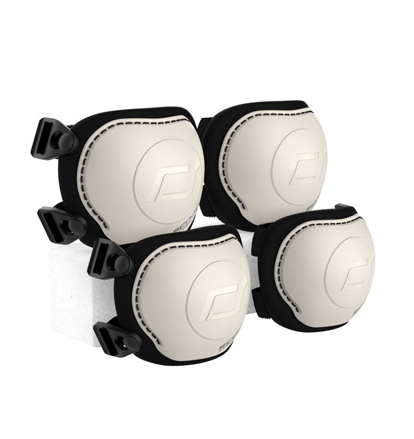 Conjunto de quatro proteções Scoot & Ride (dois joelhos e dois cotovelos) na cor bege/creme, com fechos pretos.