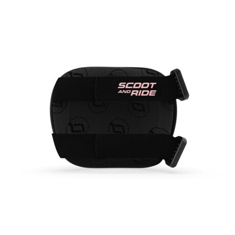 Vista traseira de uma proteção Scoot & Ride preta, evidenciando as alças ajustáveis com fecho rápido e o logótipo em cor de rosa.