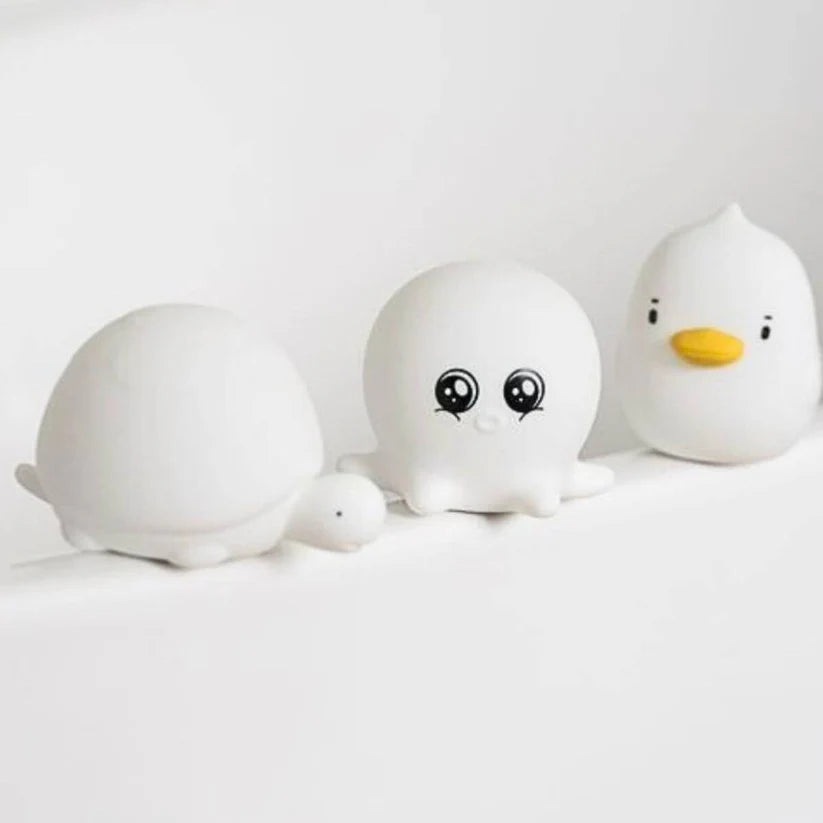 As três lâmpadas Rabbit e Friends (tartaruga, polvo, patinho) alinhadas numa superfície branca, mostrando os seus designs sem luz.