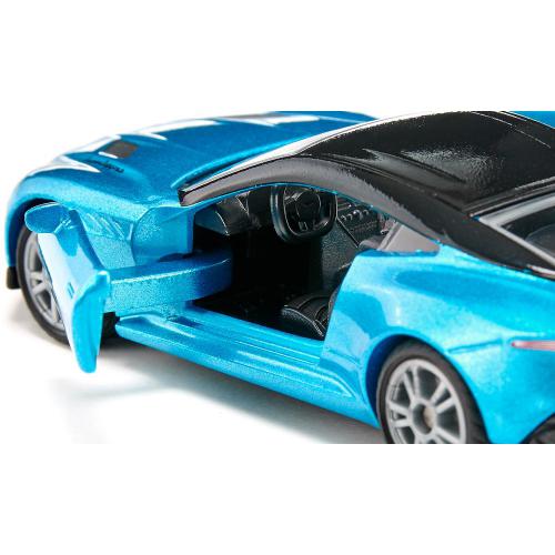 Close-up da miniatura Aston Martin DBS Superleggera azul, focando na porta do condutor aberta e no interior detalhado.
