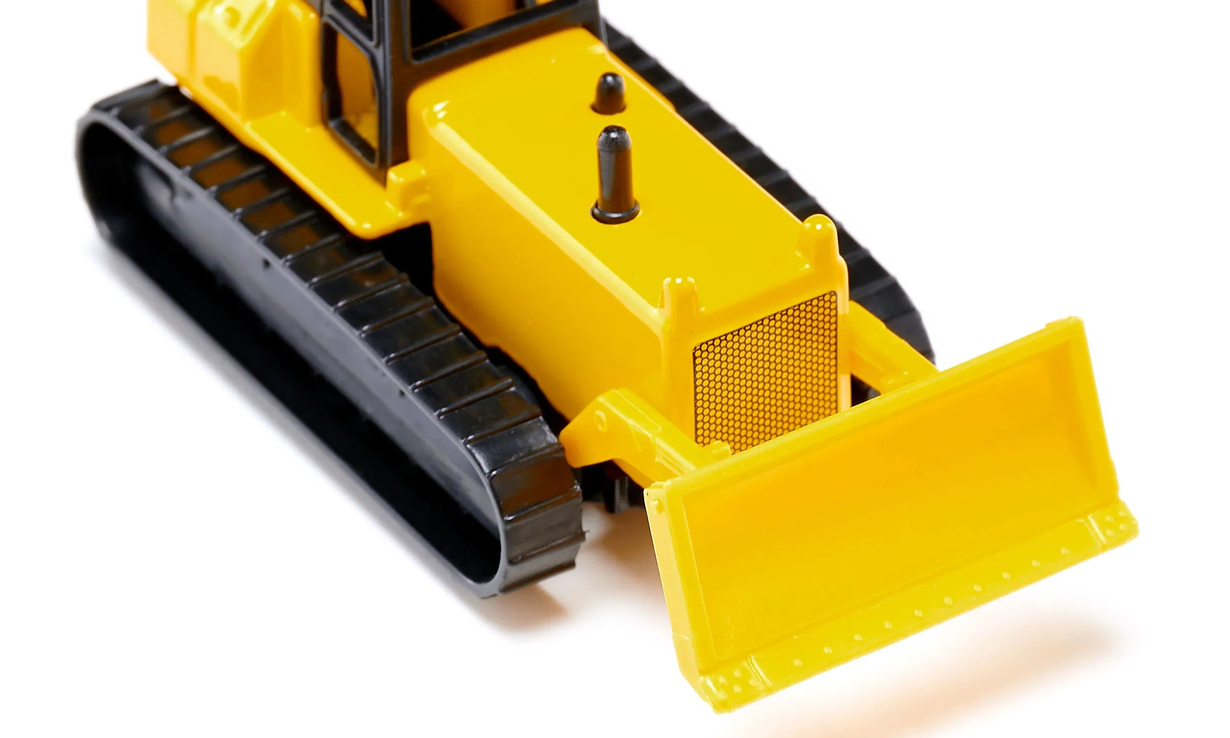 Miniatura SIKU de um bulldozer amarelo, vista frontal inclinada, destacando a lâmina móvel e as lagartas pretas.