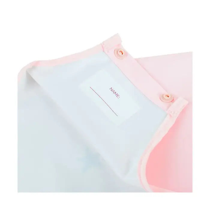 Vista aproximada do fecho de pressão ajustável no pescoço do babete Miniland, com etiqueta para nome.