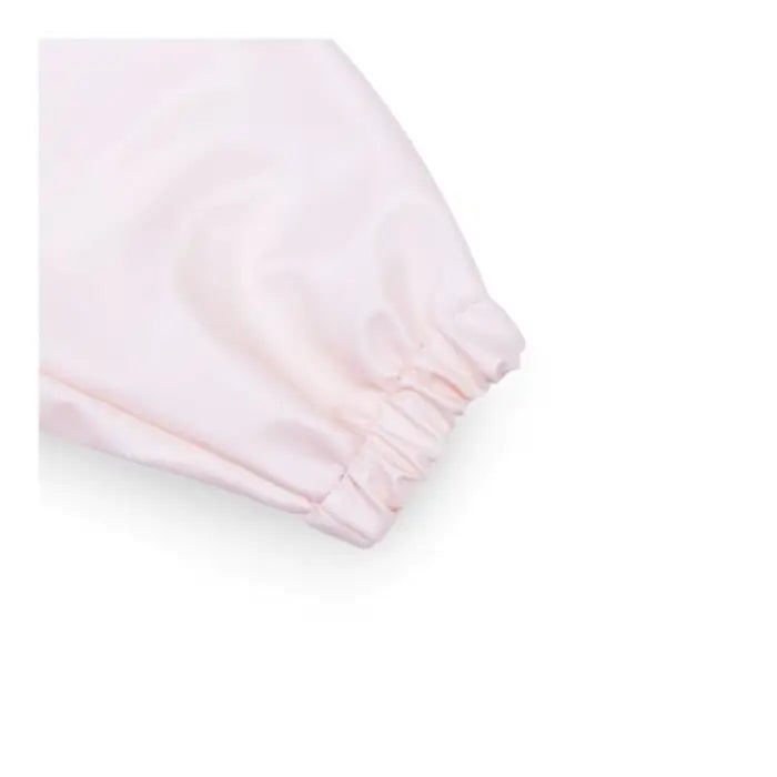 Detalhe do punho elástico da manga do babete Miniland, garantindo um ajuste confortável e proteção.