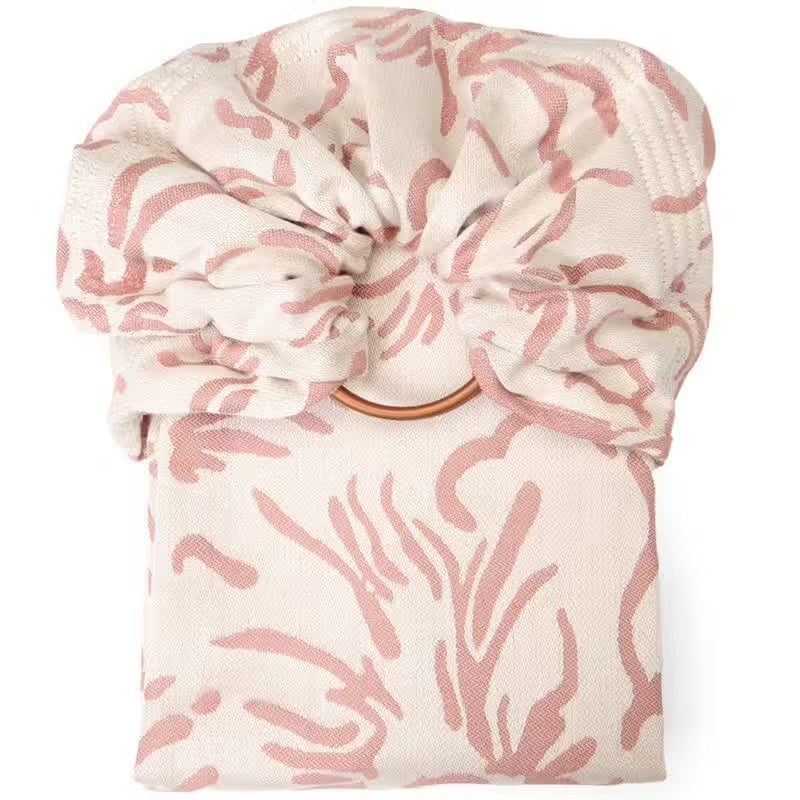 Sling de Argolas Neobulle SEA CELL beije rose dobrado, mostrando o tecido estampado e os anéis de alumínio cor de cobre.