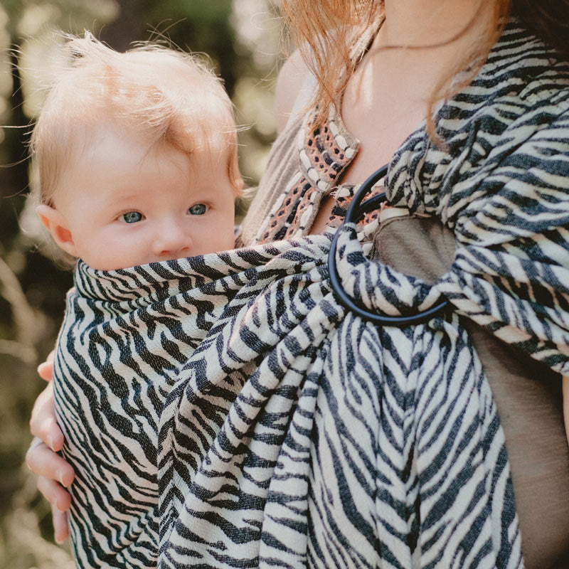 Imagem de um Sling de Argolas Néobulle JACQUARD Zèbre Noir dobrado, destacando o padrão de zebra em preto e branco.