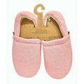 Par de pantufas Slip Stop Booties na cor rosa (Cranberry) com textura felpuda, apresentadas em embalagem de cartão reciclado com gancho.