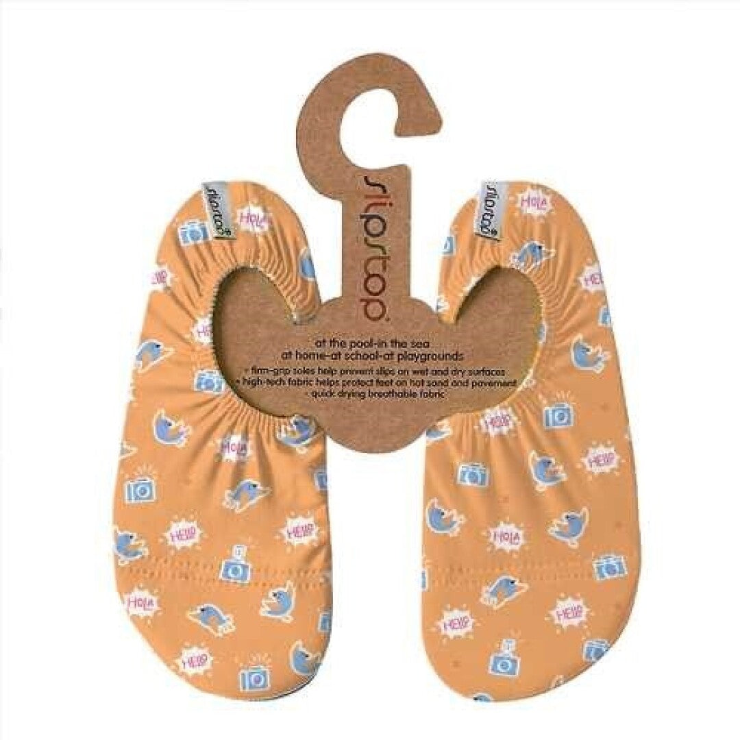 Par de meias antiderrapantes Slip Stop estilo "Flash" cor de laranja com padrão de golfinhos e câmaras, apresentadas na embalagem de cartão com informações do produto.