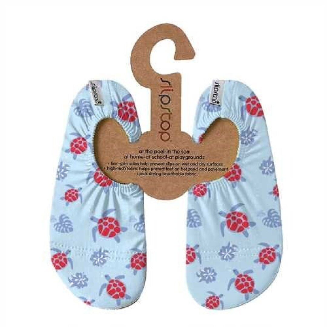 Par de meias Slip Stop antiderrapantes com padrão de tartarugas vermelhas e flores azuis, apresentadas em cabide de cartão com informações do produto.