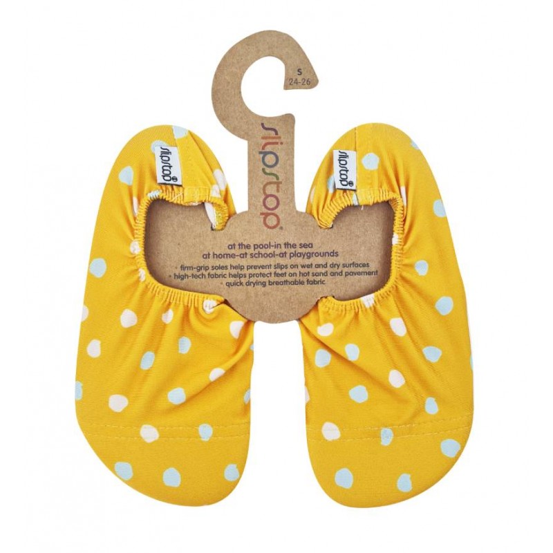 Par de meias antiderrapantes Slip Stop amarelas com lunares azuis e brancos, exibidas num cabide de cartão.