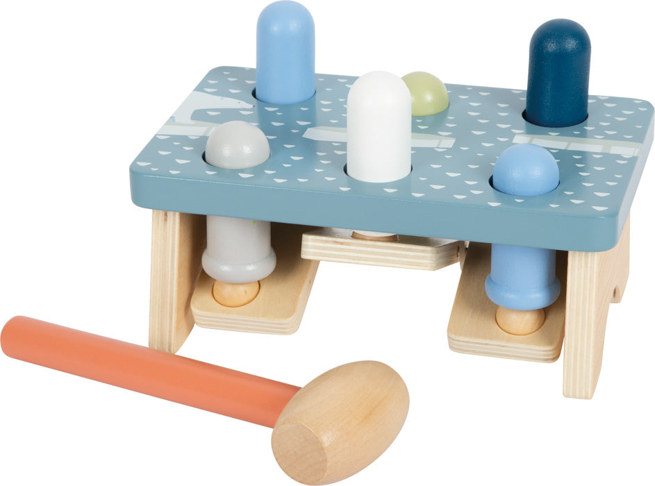 Jogo de martelar em madeira Small Foot, com base azul Ártico e pinos coloridos. O martelo de madeira com cabo laranja está ao lado.