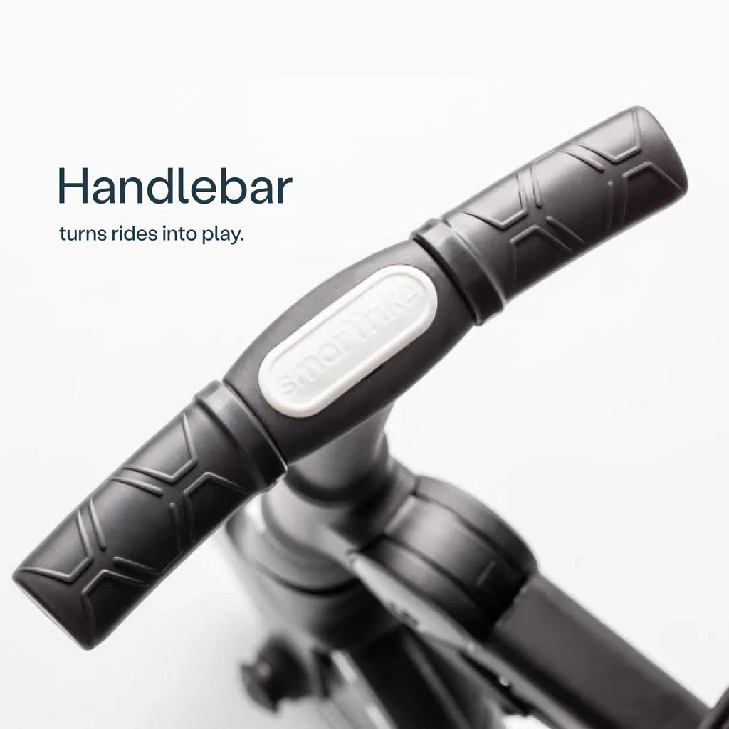 Detalhe do guiador preto texturizado do SMARTRIKE Traveler com o logótipo Smartrike em relevo, destacando a ergonomia.