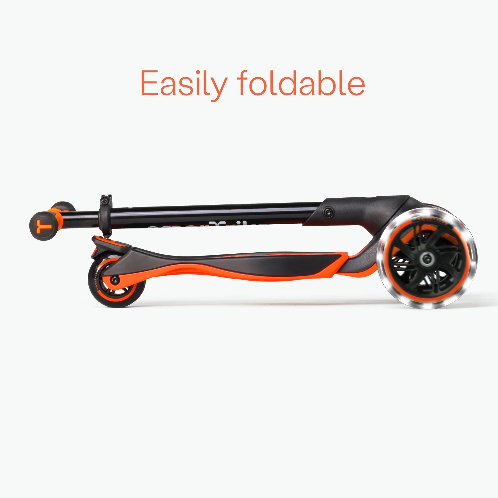 Trotinete Smartrike Xtend dobrada para arrumação, mostrando o mecanismo de fecho fácil e a roda LED frontal.