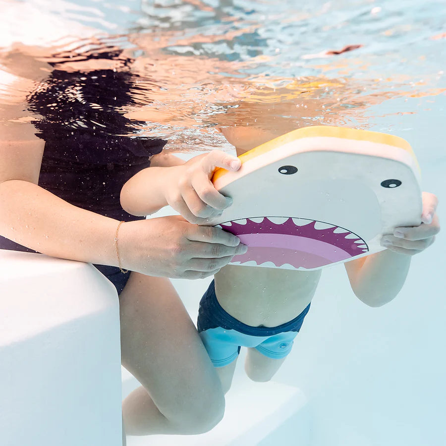 Adulto a ajudar uma criança debaixo de água a segurar a prancha de natação Splash About Kickboard Shark Grey, mostrando o apoio na aprendizagem.