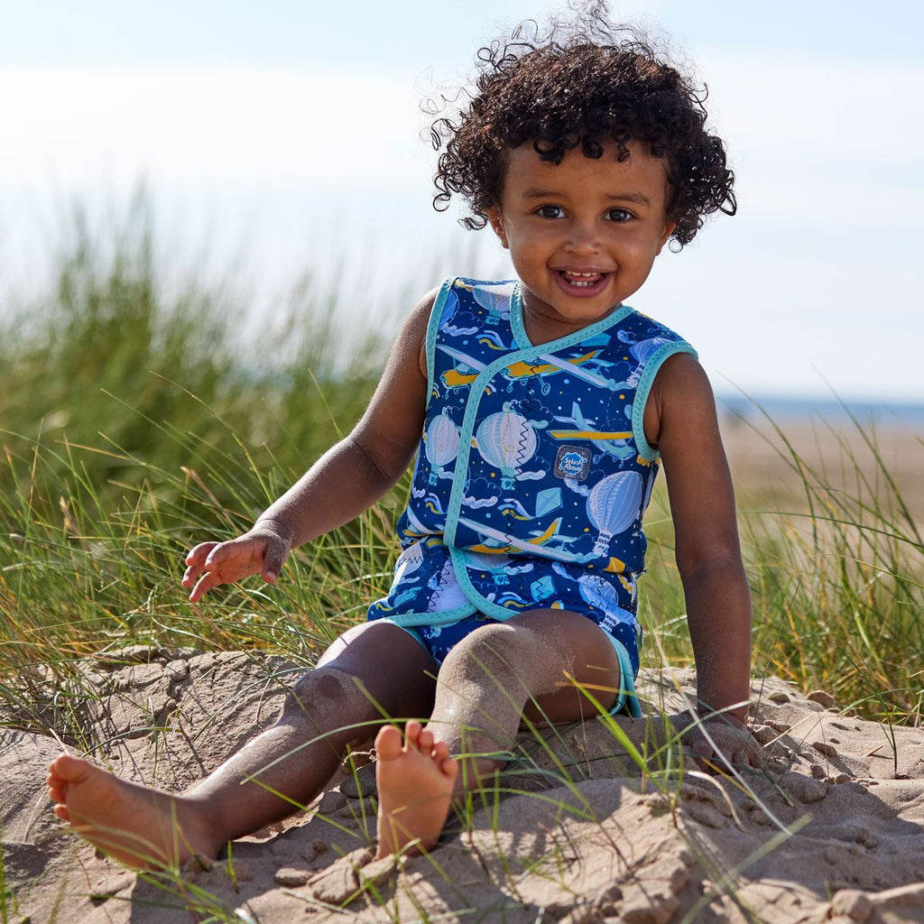 Fato de praia/piscina térmico Splash About Baby Wrap™ em neoprene azul, aberto para mostrar o fecho de velcro ajustável e o design de corpo completo com braços e pernas livres.