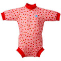 Fato de praia/piscina térmico Happy Nappy™ Wetsuit Splash About, cor de rosa com padrão de morangos e acabamentos vermelhos, visto de frente.