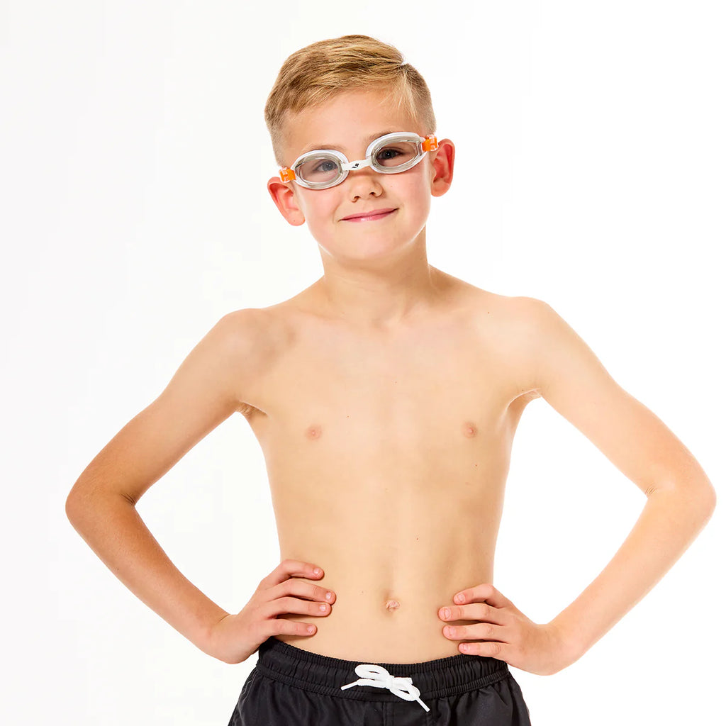 Criança sorridente a usar os óculos de piscina Soaked Junior Piranha, demonstrando o conforto e a visão clara anti-reflexo durante a natação.