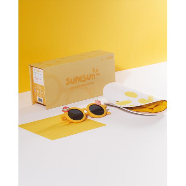 Kit de óculos de sol Sumsun amarelos, caixa amarela, pano de limpeza e acessórios decorativos sobre fundo branco e amarelo vibrante.
