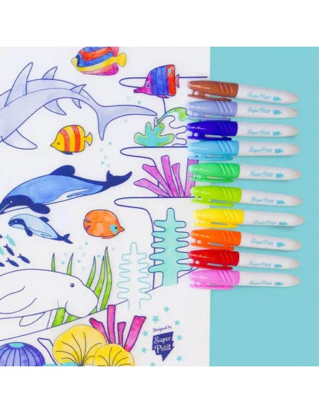 Dez marcadores SuperPetit alinhados sobre um tapete de silicone parcialmente colorido com temática marinha, mostrando as cores vibrantes das pontas.