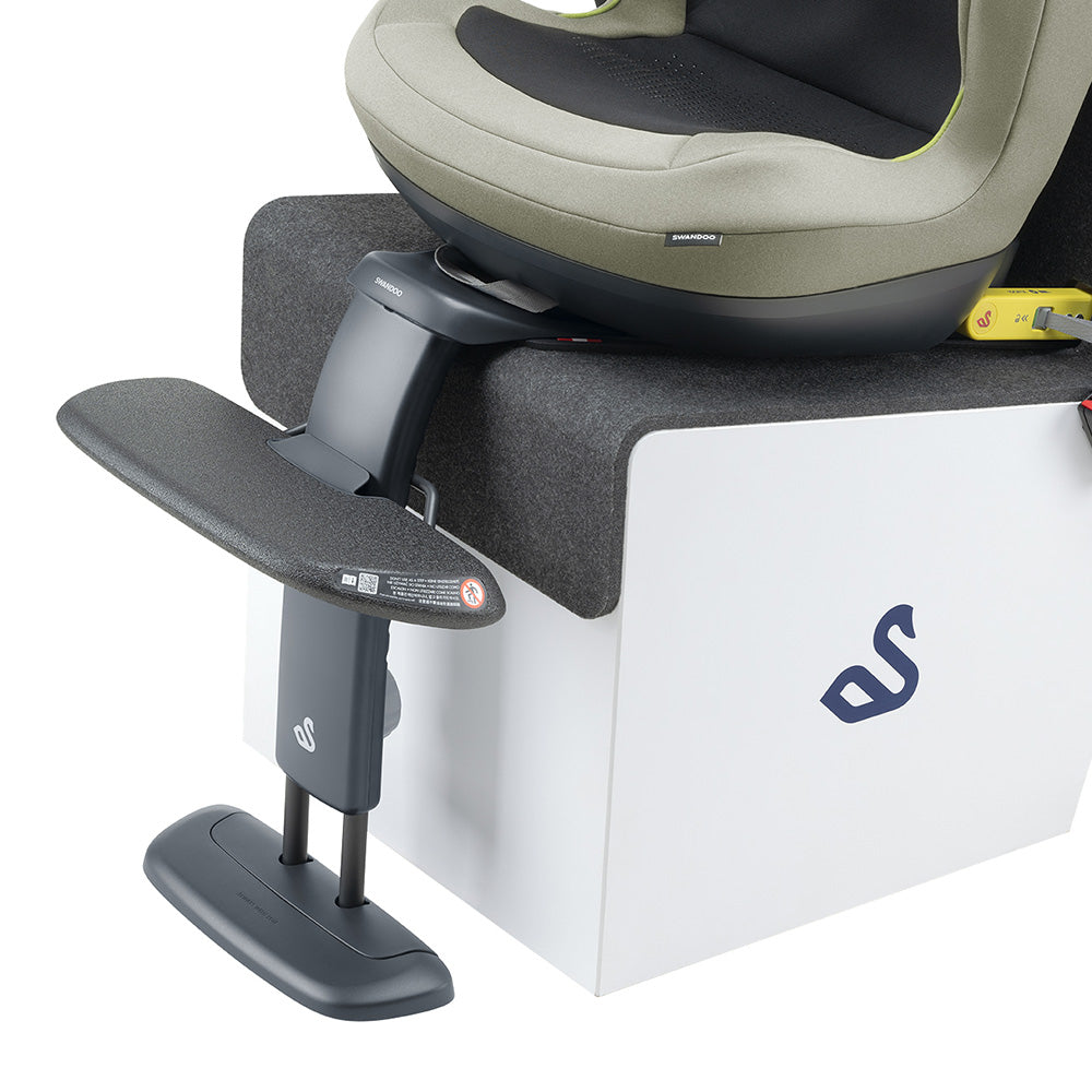 Detalhe do apoio universal Swandoo instalado sob um assento auto, fixado ao encosto do banco, demonstrando o suporte ergonómico.