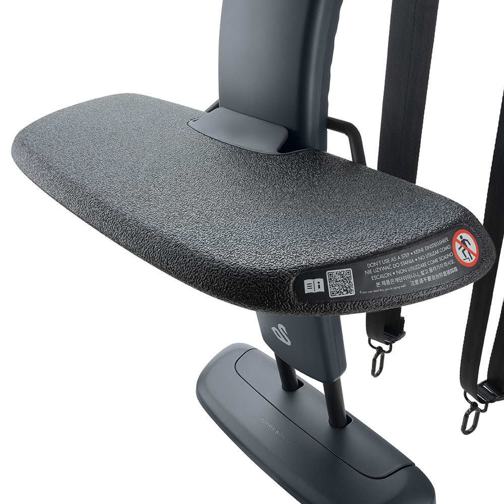 Detalhe da plataforma antiderrapante do apoio de pés Swandoo, mostrando avisos de segurança em várias línguas e um código QR.